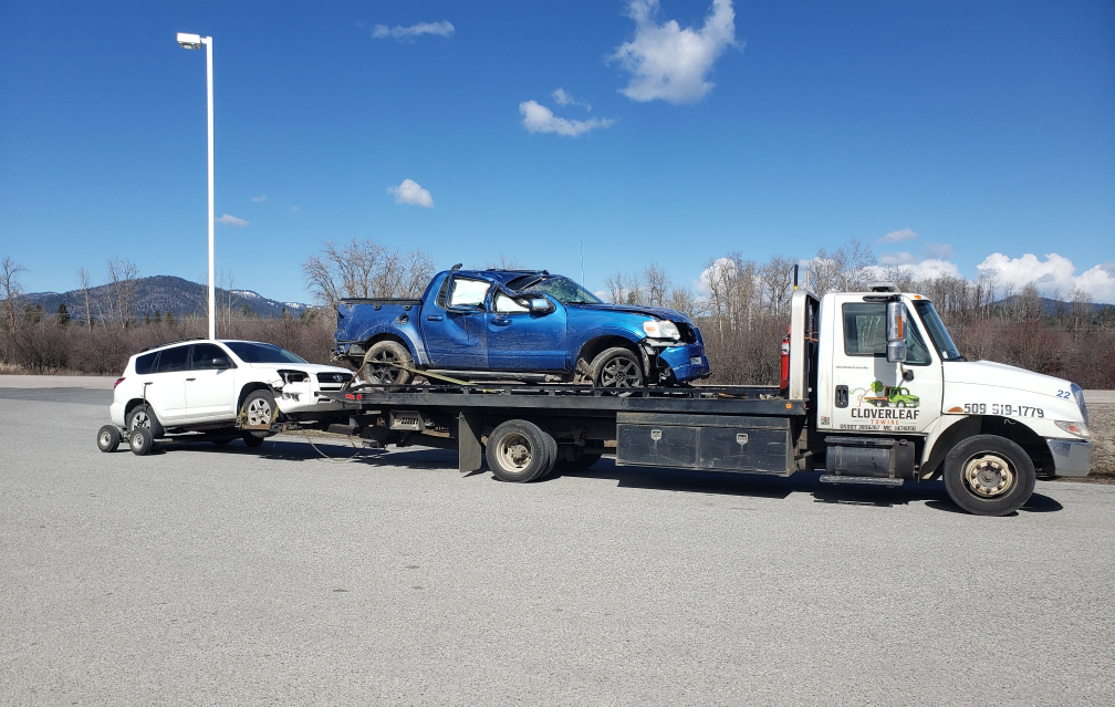 Cloverleaf Towing flat ben with 2 cars loaded up