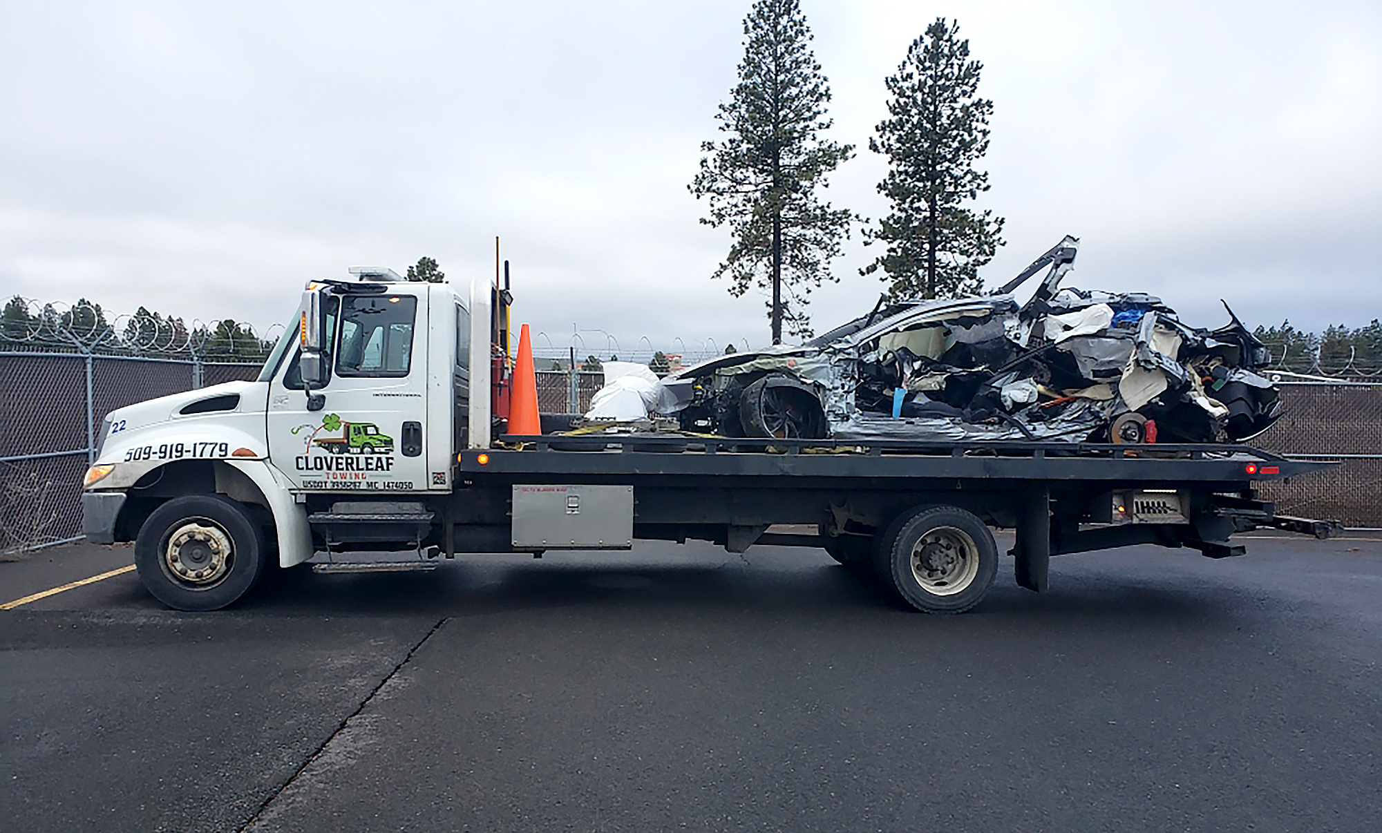Flatbed tow truck with a wrecked car
